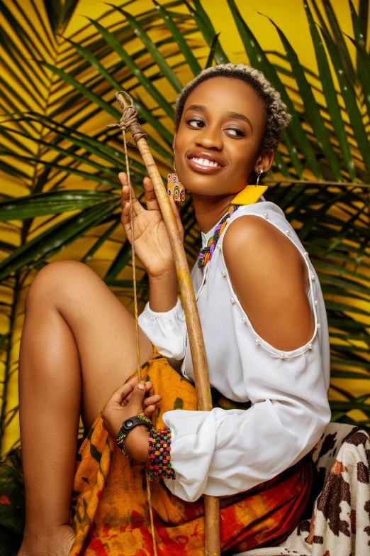 a woman sitting on top of a pile of luggage, an album cover, inspired by Chinwe Chukwuogo-Roy, trending on pexels, holding a bow and arrow, smiling young woman, full frame image, wearing yellow croptop