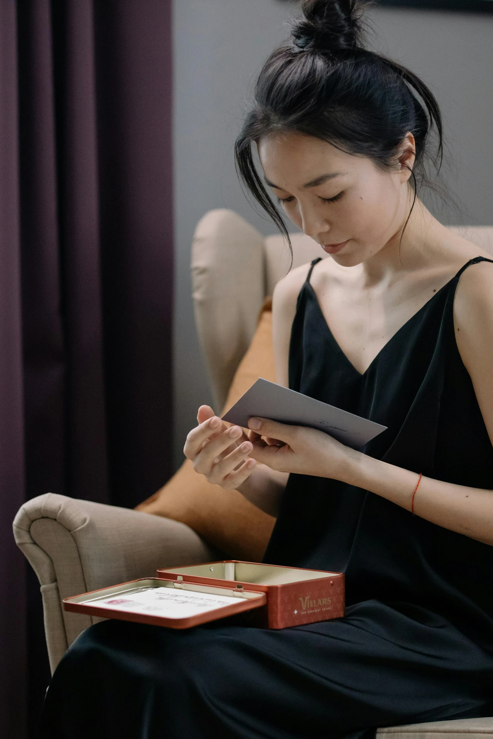 a woman sitting in a chair reading a book, an album cover, inspired by Fei Danxu, pexels contest winner, holding gift, smooth tiny details, box, thoughtful expression