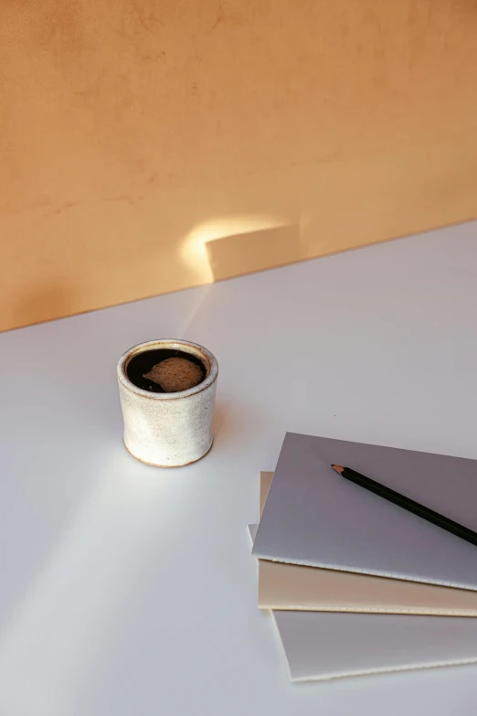 a cup of coffee sitting on top of a white table, inspired by jeonseok lee, light and space, tin can, ambient lighting from top, detailed product image, light tan