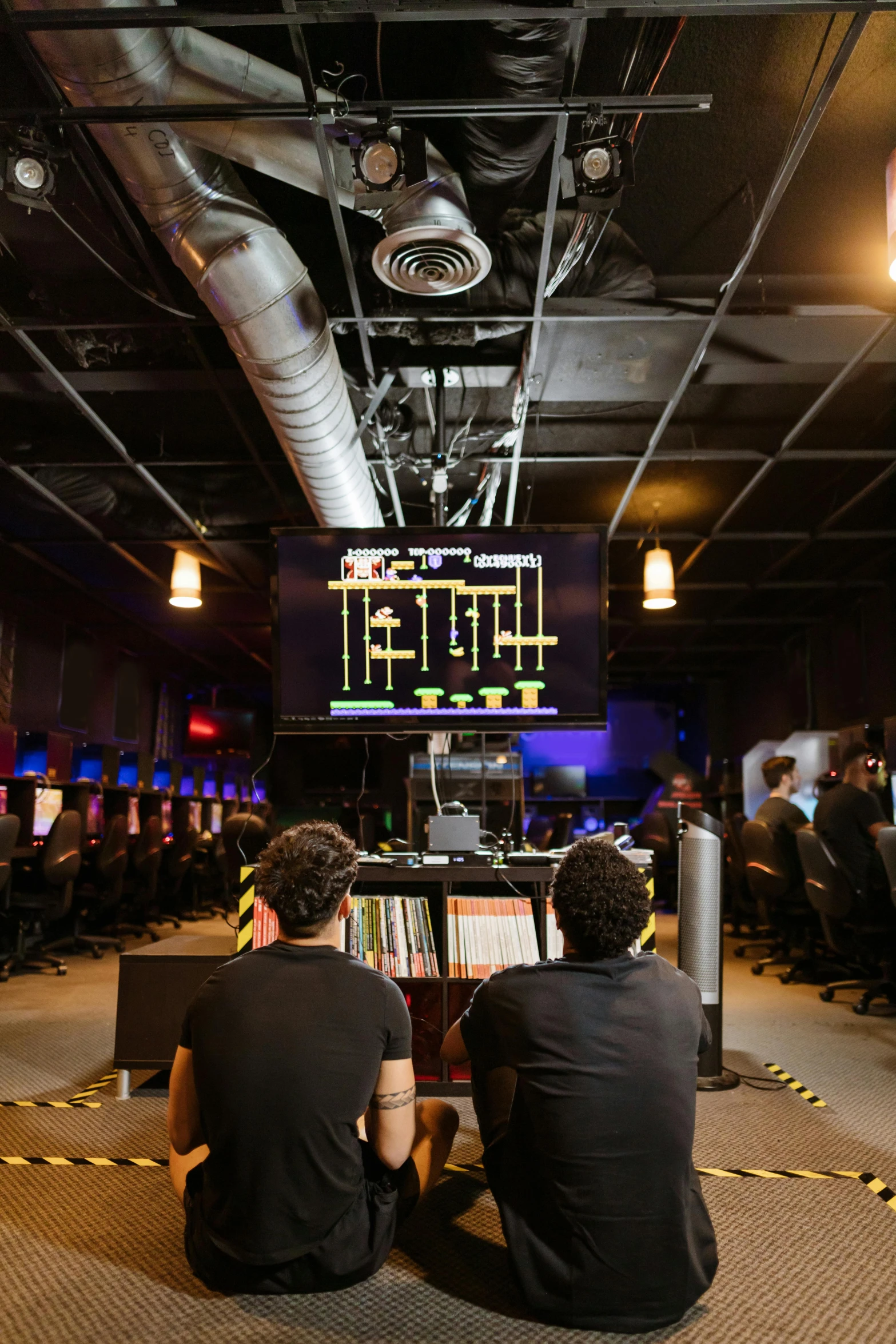 a couple of men sitting next to each other in a room, reddit, underground lab, arcade, pictured from the shoulders up, sitting at a control center