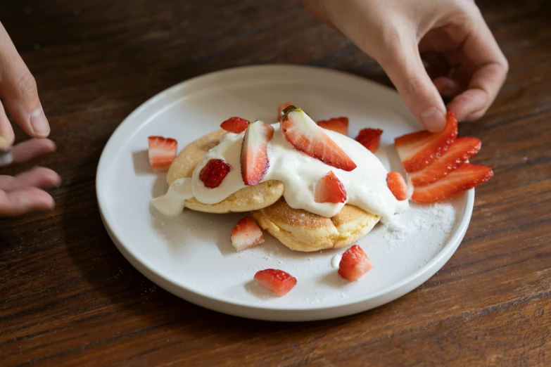 a white plate topped with pancakes and strawberries, by Lucette Barker, sydney, sleek hands, cream, 6 pack