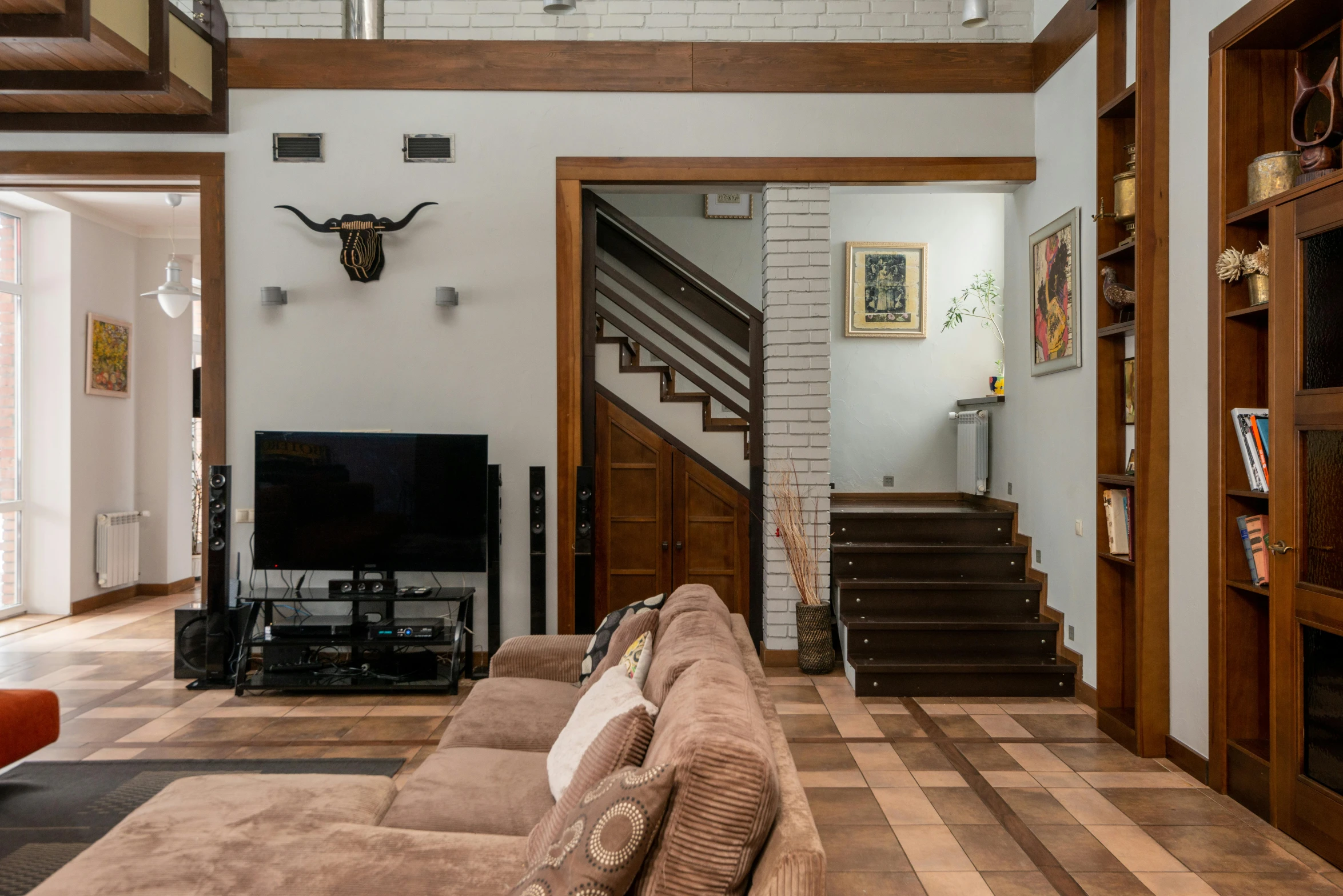 a living room filled with furniture and a fire place, inspired by Carlos Francisco Chang Marín, pexels contest winner, modernism, stairs to an upper floor, brown, nostalgic 8k, above the family room