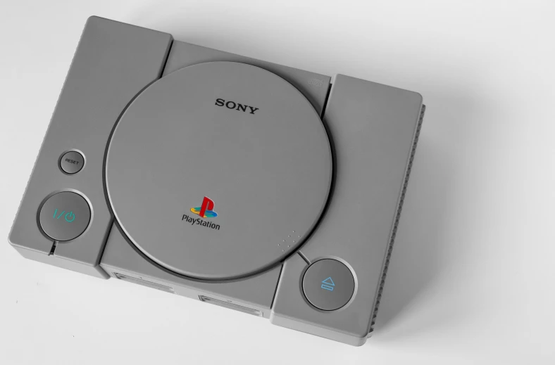 a sony game system sitting on top of a table, a low poly render, inspired by Josef Šíma, computer art, high angle close up shot, grey metal body, ultra realistic classic, ps 1