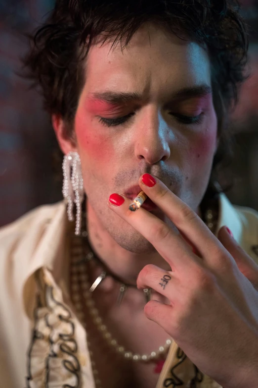 a close up of a person smoking a cigarette, an album cover, inspired by Nan Goldin, renaissance, here's johnny, drag, jay bauman, ( ( theatrical ) )