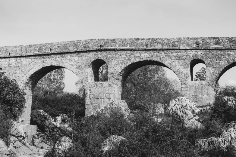 a black and white photo of a stone bridge, les nabis, conversano, meni chatzipanagiotou, 🧒 📸 🎨, panorama