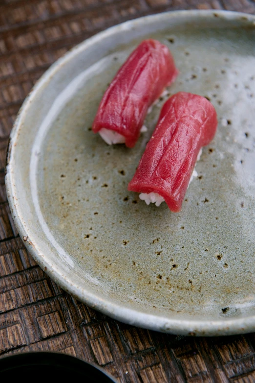 a close up of a plate of food on a table, mingei, streamlined spines, crimson, slate, no grain