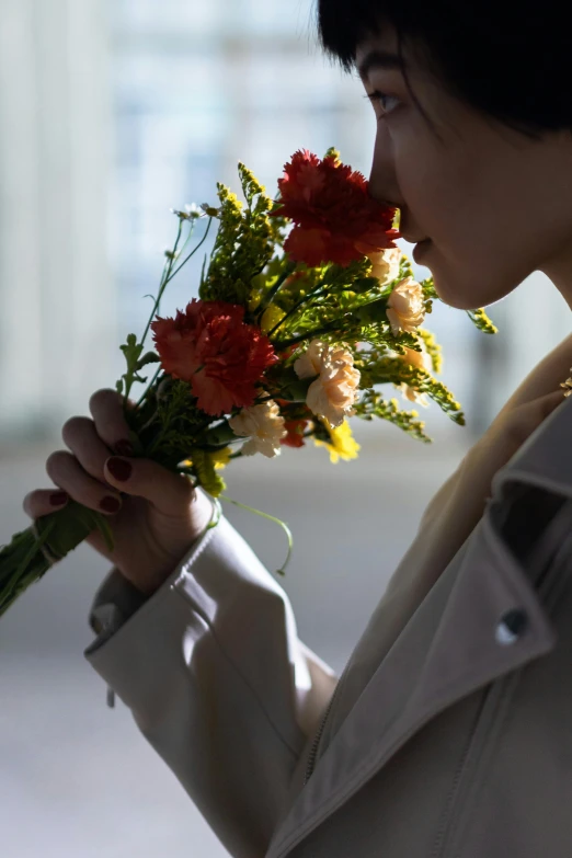 a woman holding a bunch of flowers in her hand, softly shadowed, kissing, korean woman, photographed for reuters