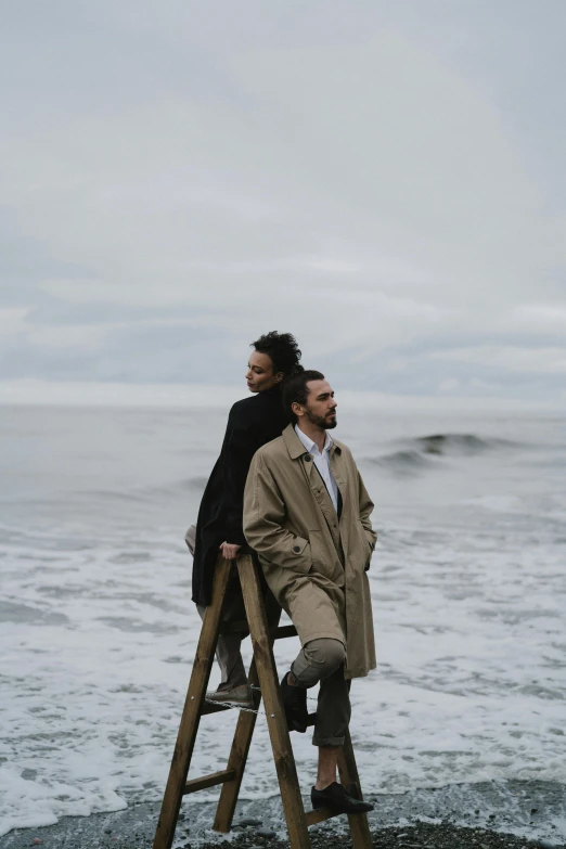 a man and a woman sitting on a ladder next to the ocean, a portrait, pexels contest winner, romanticism, gray sky, gif, in rough seas with large waves, walking together