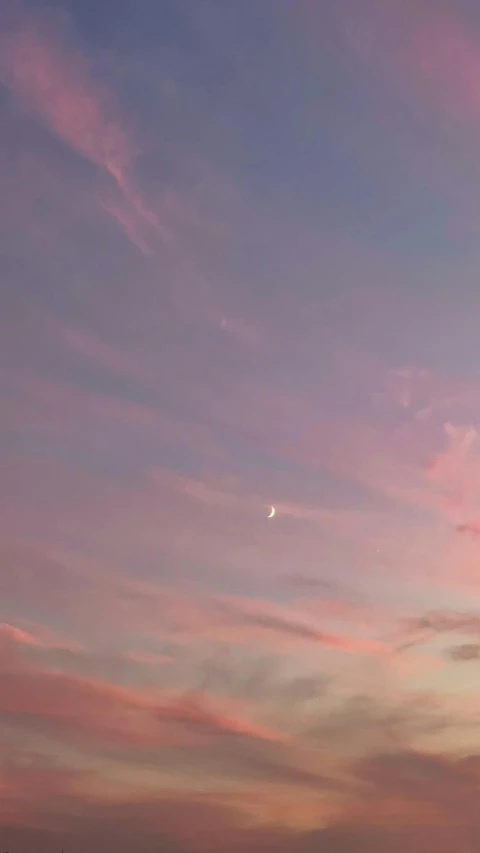 there is a plane that is flying in the sky, unsplash, aestheticism, pink moon, low quality photo, in pastel colors, crescent moon