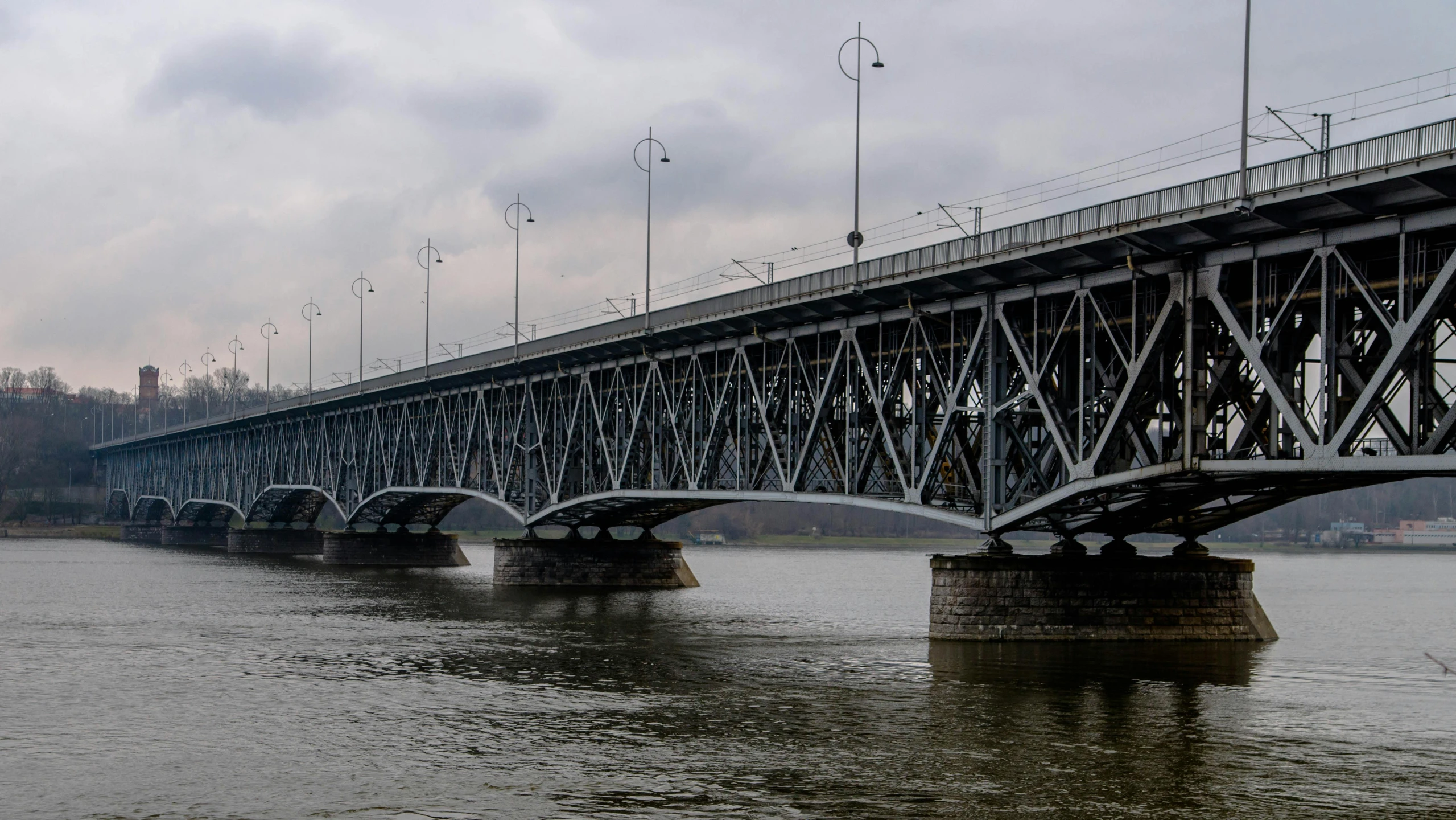 a bridge over a body of water under a cloudy sky, by Josef Navrátil, pexels contest winner, art nouveau, neo kyiv, slide show, aluminum, slight overcast weather