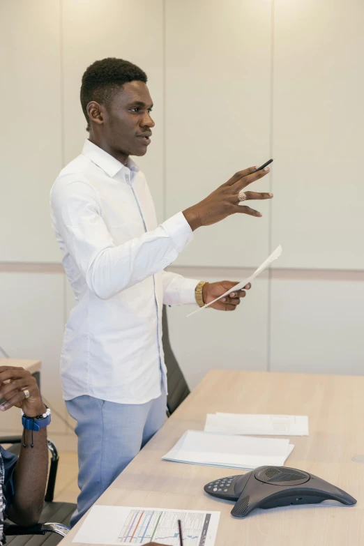 a man giving a presentation to a group of people, pexels contest winner, academic art, african canadian, model pose, looking left, teaching