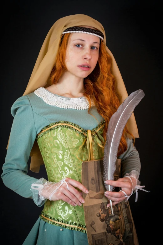 a woman dressed in medieval clothing holding a feather, with red hair and green eyes, photograph taken in 2 0 2 0, sqare-jawed in medieval clothing, storybook style