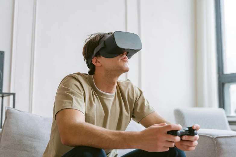 a man sitting on a couch playing a video game, by Carey Morris, shutterstock, hyperrealism, goggles on forehead, trending on unreal engine 5, visor covering eyes, no - text no - logo