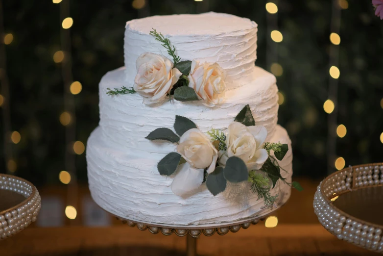 a white wedding cake sitting on top of a table, by Robbie Trevino, unsplash, kek, closeup - view, brown, textured