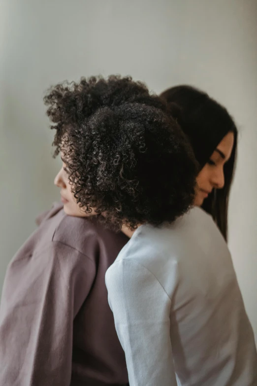 a couple of women standing next to each other, trending on pexels, renaissance, sweet hugs, (dark shorter curly hair), supportive, muted brown