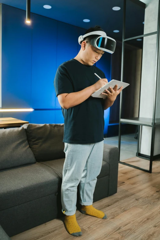 a man standing in a living room wearing a virtual reality headset, pexels contest winner, holography, asian male, studying, fullbody view, sleek visor