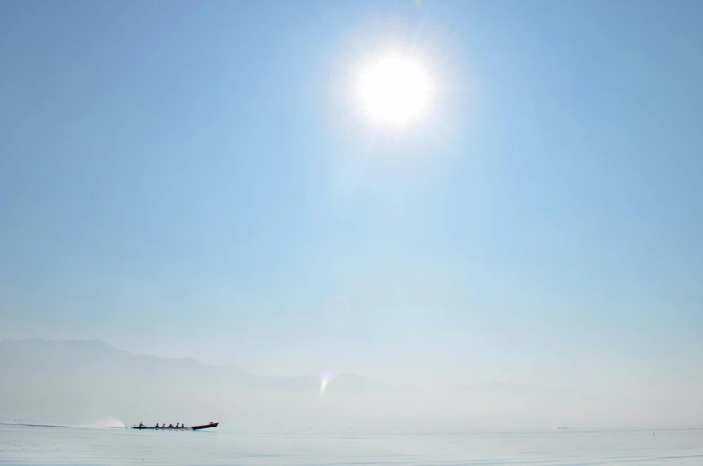 a group of people riding skis on top of a snow covered slope, by Yasushi Sugiyama, pexels contest winner, minimalism, boat with lamp, hazy sun and mystical, the dead sea, myanmar