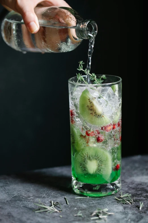 a person pouring a drink into a glass, trending on pexels, hurufiyya, kiwi, with sparkling gems on top, ivy's, on grey background