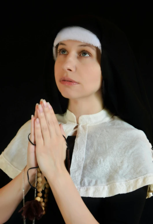 a woman dressed as a nun holding a rosary, an album cover, inspired by Barthélemy d'Eyck, unsplash, cosplay, actress, ( ( theatrical ) ), had