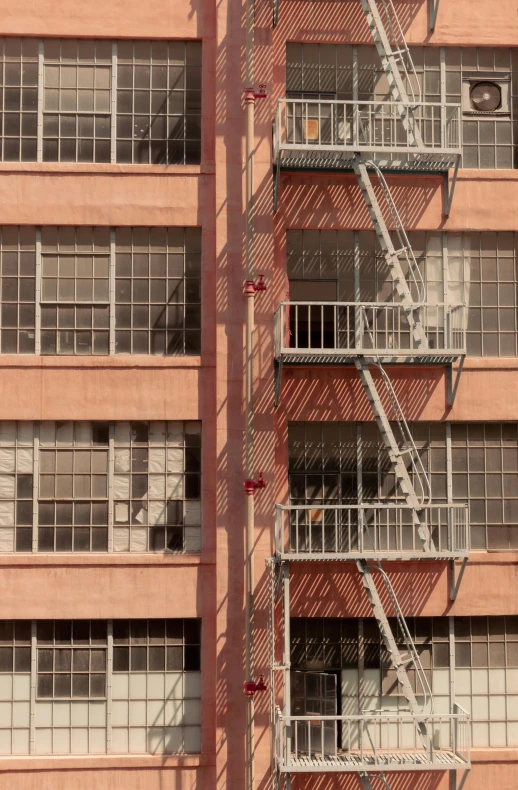 a fire escape on the side of a building, a photo, inspired by Robert Bechtle, modernism, 1960s color photograph, bay area, ignant, faded red colors