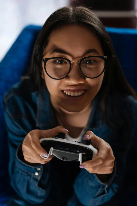 a woman in glasses holding a video game controller, inspired by Feng Zhu, pexels contest winner, smiling down from above, glass oled visor head, mai anh tran, portrait mode