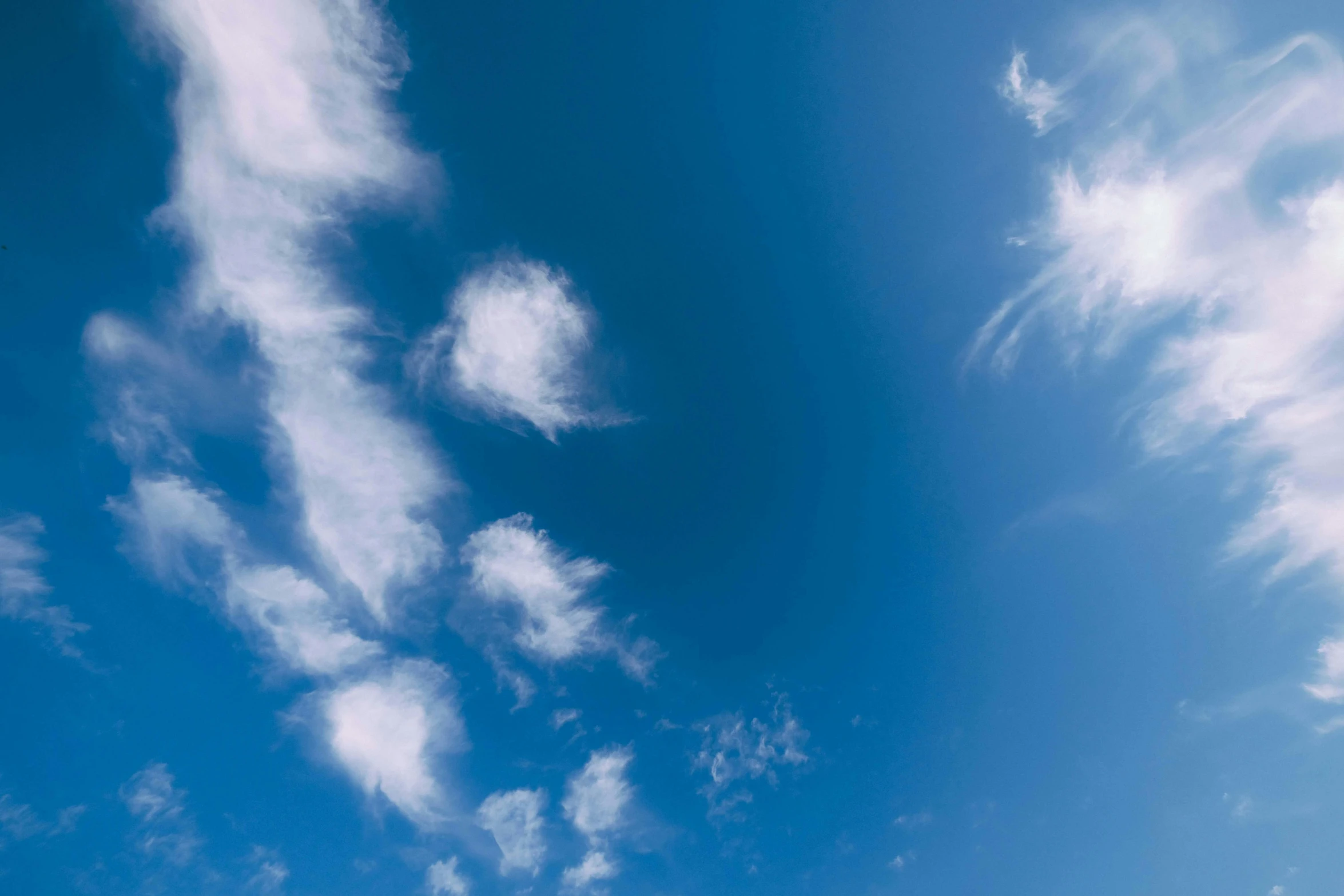 a man flying a kite on top of a lush green field, unsplash, minimalism, among heavenly sunlit clouds, light blues, ignant, round clouds