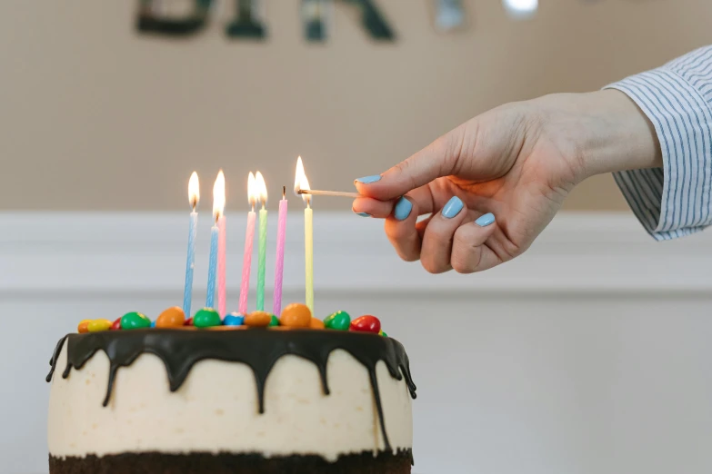 a person lighting candles on a birthday cake, by Julia Pishtar, pexels, hyperrealism, background image, super high resolution, multiple stories, cutest