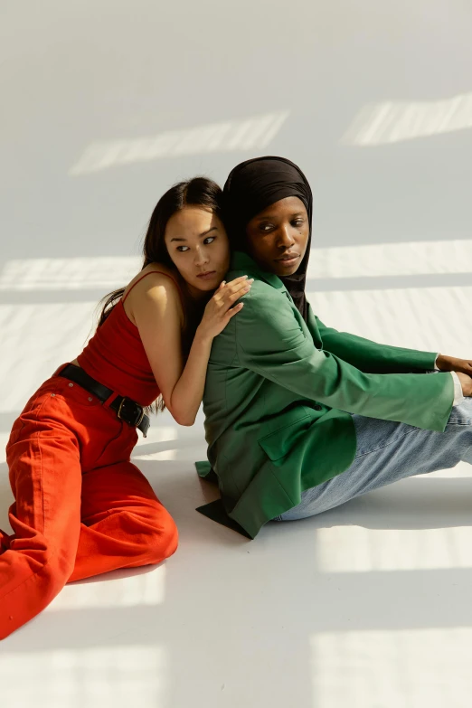 two women sitting next to each other on the floor, inspired by Wang Duo, trending on pexels, renaissance, red green, ashteroth, standing sideways, muslim