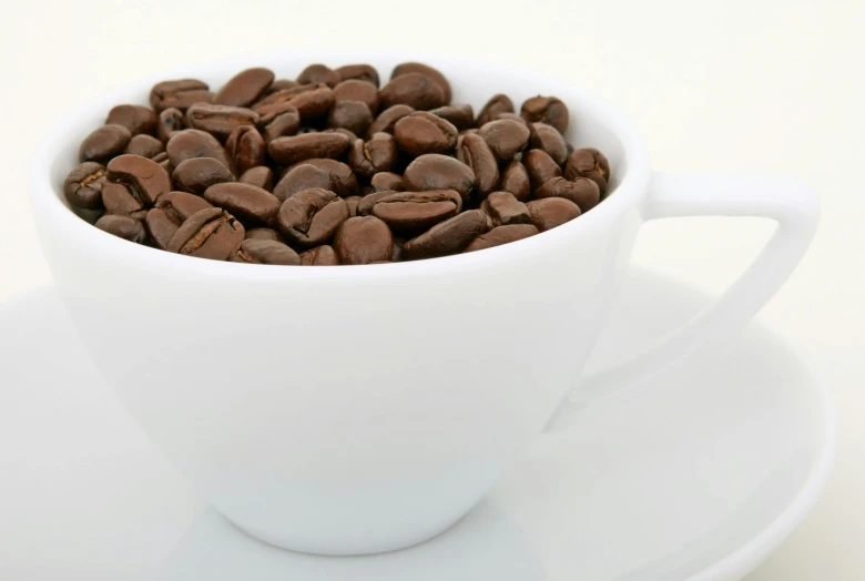 a cup filled with coffee beans on top of a saucer, detailed product image, zoomed in, fan favorite, medium-shot