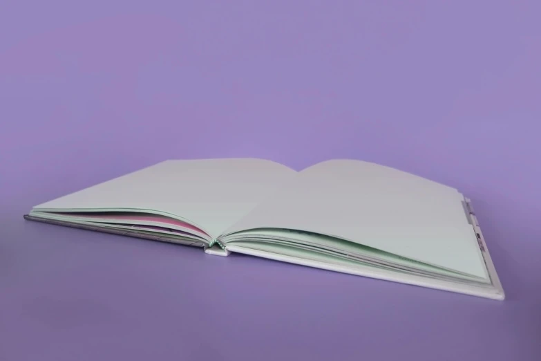 an open book sitting on top of a table, unsplash, color field, pastel purple background, low quality photo, animation, made of silk paper
