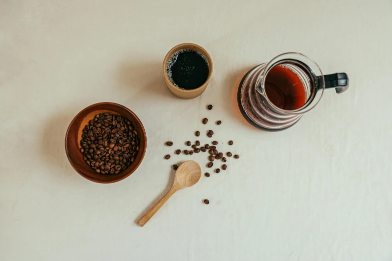 a table topped with coffee beans and a wooden spoon, a still life, trending on unsplash, cold brew coffee ), gif, minimalist photo