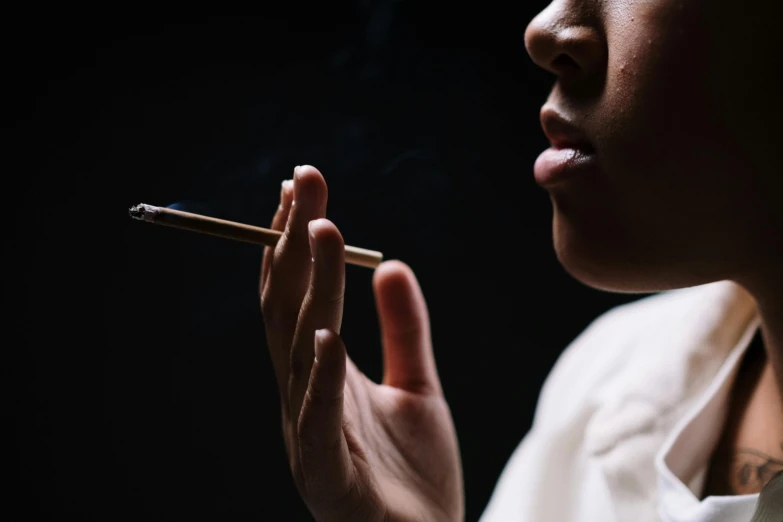 a close up of a person holding a cigarette, unsplash, hyperrealism, kara walker, thc, profile picture, late night