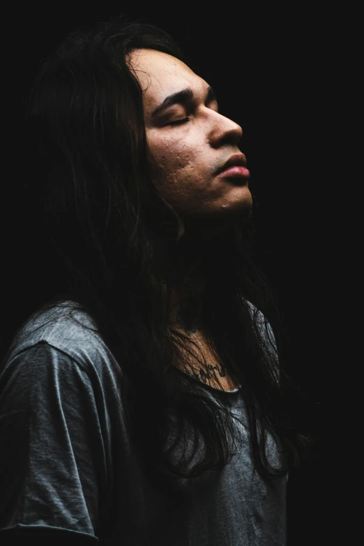 a woman standing in the dark with her eyes closed, an album cover, inspired by Jorge Jacinto, portrait of young man, with his long black hair, portrait mode photo, ((portrait))