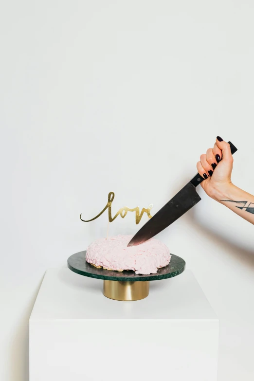 a woman cutting a cake with a knife, an album cover, by Nicolette Macnamara, trending on unsplash, love craft, gilt metal, pink, i love you