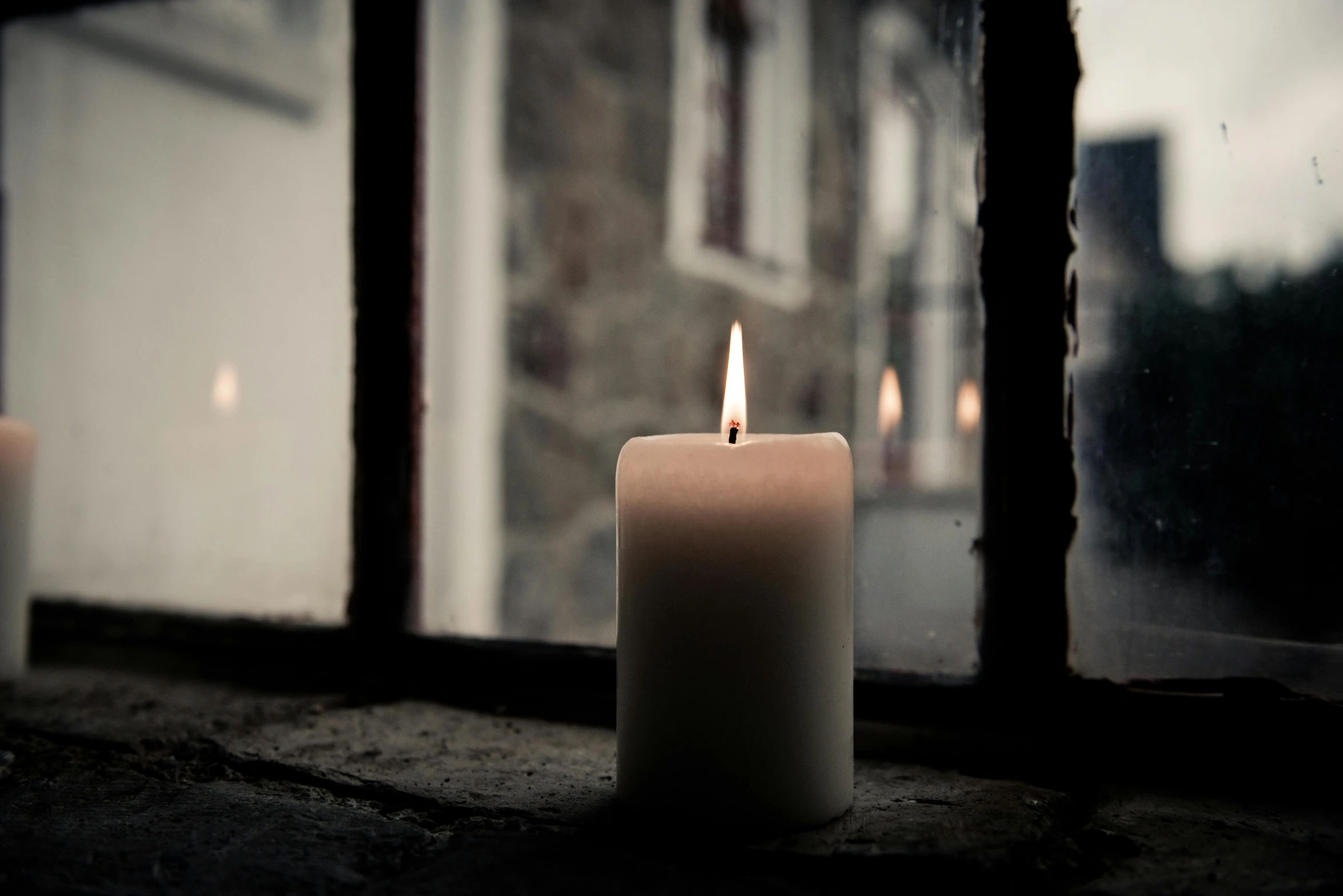 a lit candle sitting in front of a window, profile image