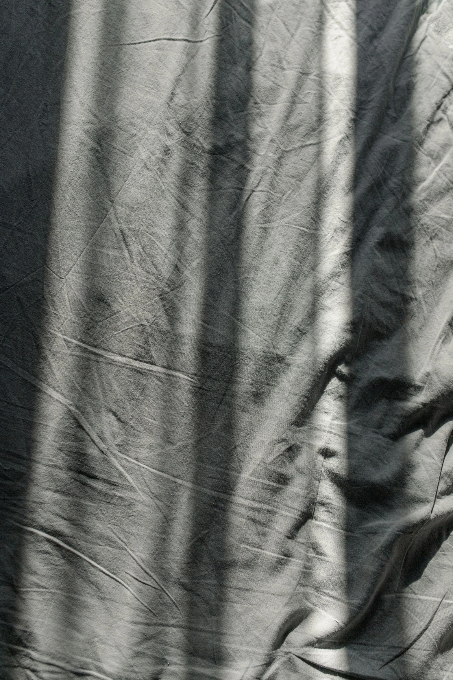 a black and white photo of a man on a skateboard, an abstract drawing, inspired by Roy DeCarava, unsplash, lyrical abstraction, folds of fabric, morning detail, tents, soft morning light. hyperrealism