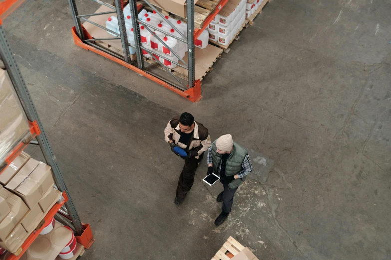 a couple of men standing next to each other in a warehouse, pexels contest winner, aerial shot, thumbnail, inspect in inventory image, people walking around