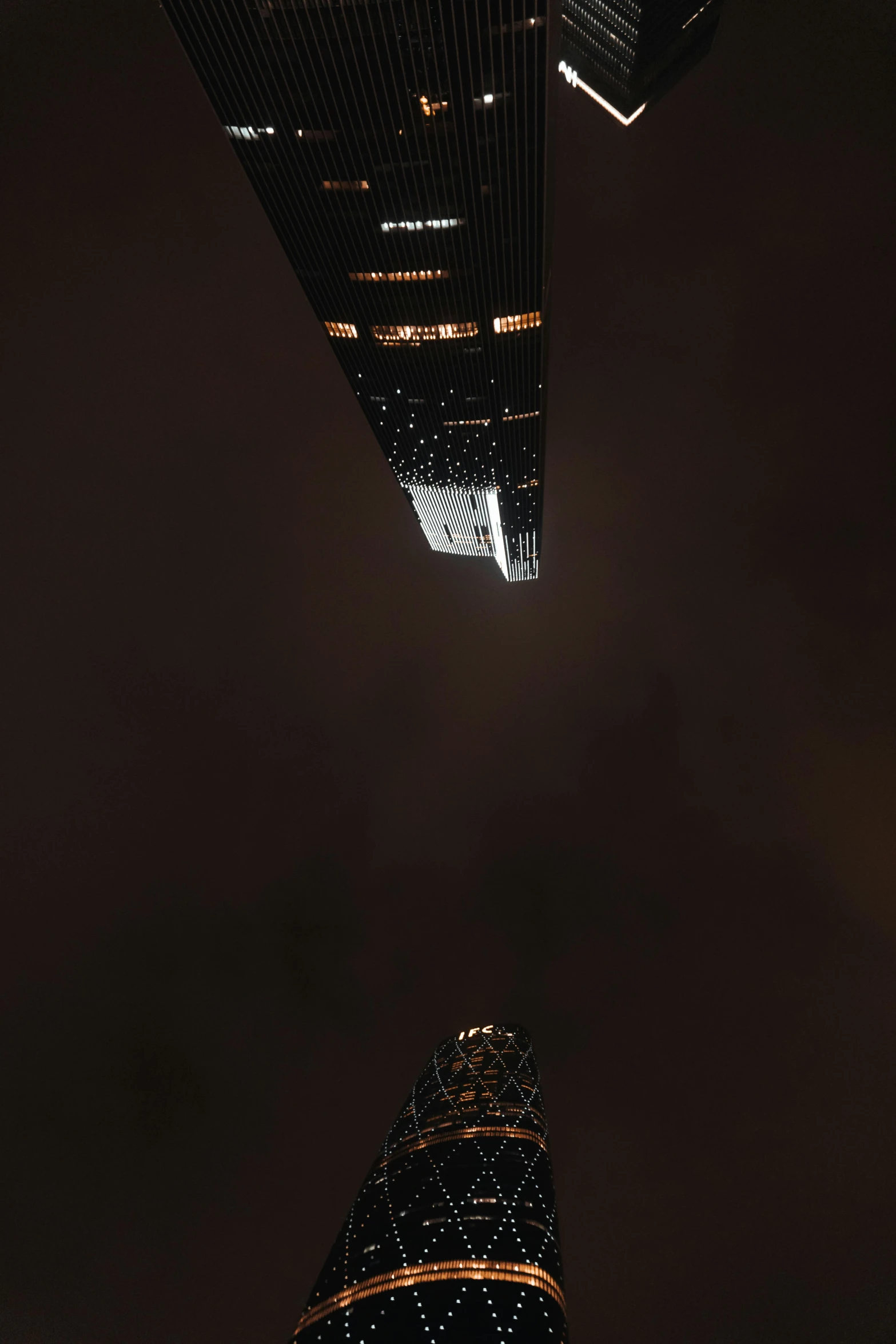 a couple of tall buildings sitting next to each other, a picture, by Jacob Pynas, flying over dark gotham, times square, low angle!!!!, low quality photo