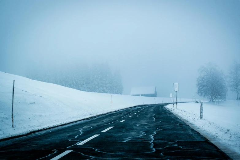 a snow covered road on a foggy day, by Matthias Weischer, pexels contest winner, white and blue, side, cold color, black road