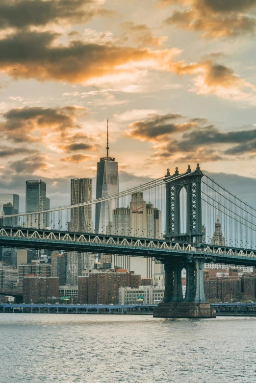 a bridge over a body of water with a city in the background, pexels contest winner, hudson river school, frank gehry, a blond, gotham, a cozy