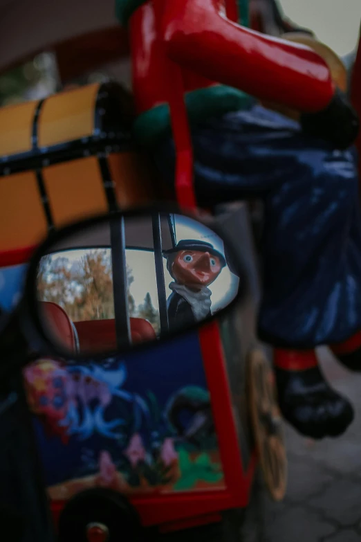 a toy man riding on the back of a motorcycle, inspired by George Luks, unsplash, photorealism, inside mirror, kombi, chucky, carousel