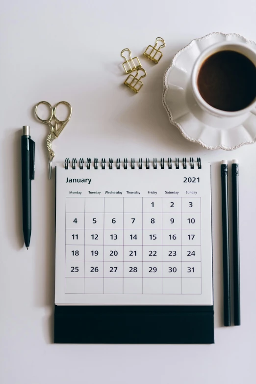 a calendar sitting on top of a desk next to a cup of coffee, by Carey Morris, trending on unsplash, thumbnail, russia in 2 0 2 1, knolling, new years eve