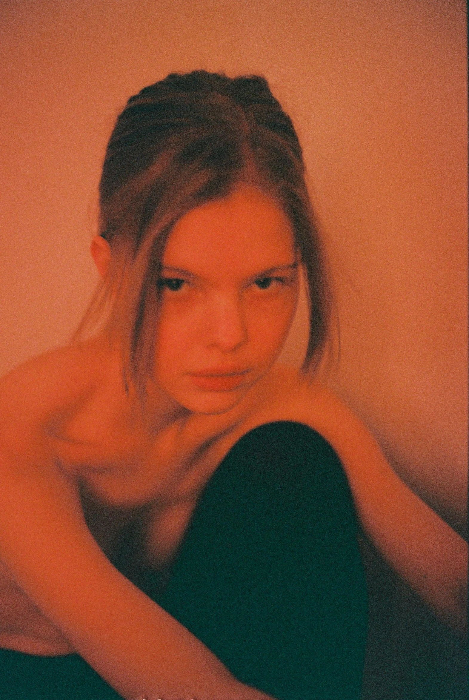 a woman sitting on top of a bed next to a wall, inspired by Nan Goldin, instagram, anya taylor - joy, aged 13, lara stone, her skin is light brown