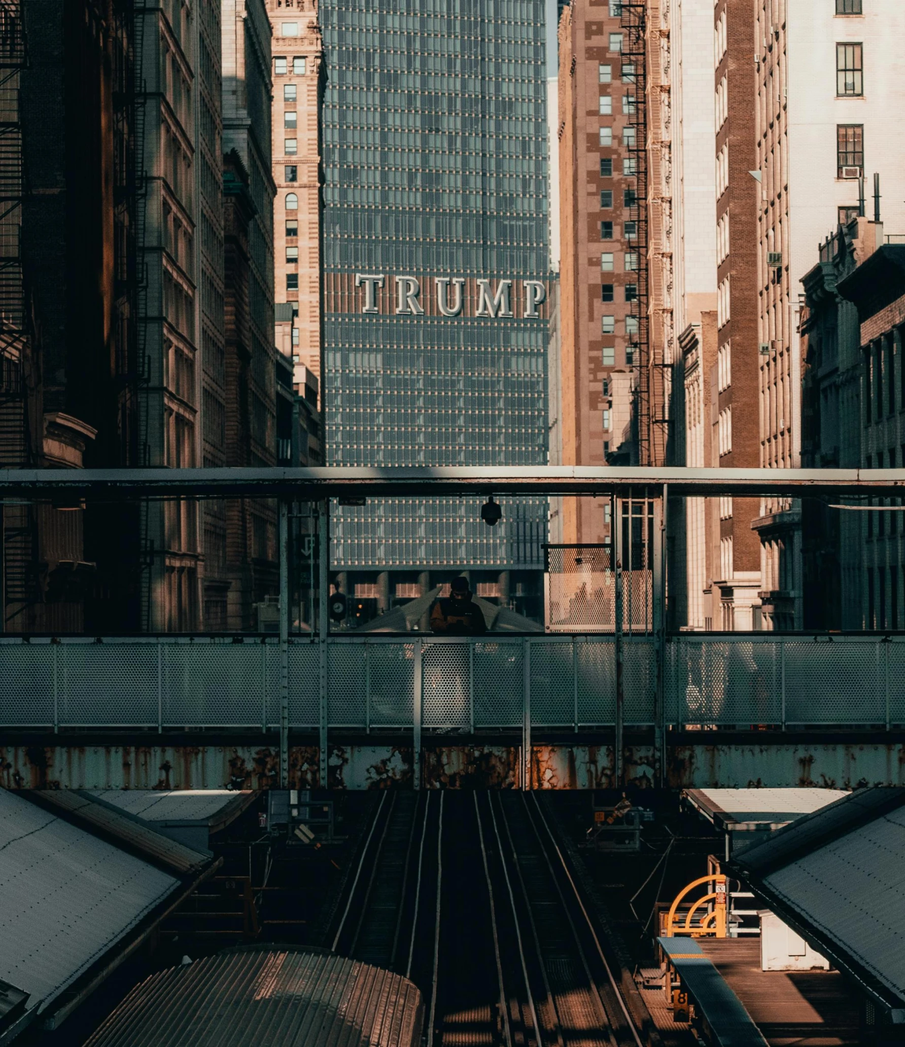 a train traveling through a city next to tall buildings, inspired by Thomas Struth, unsplash contest winner, modernism, photo of donald trump, tall terrace, ( ( cyberpunk ) ), damien tran