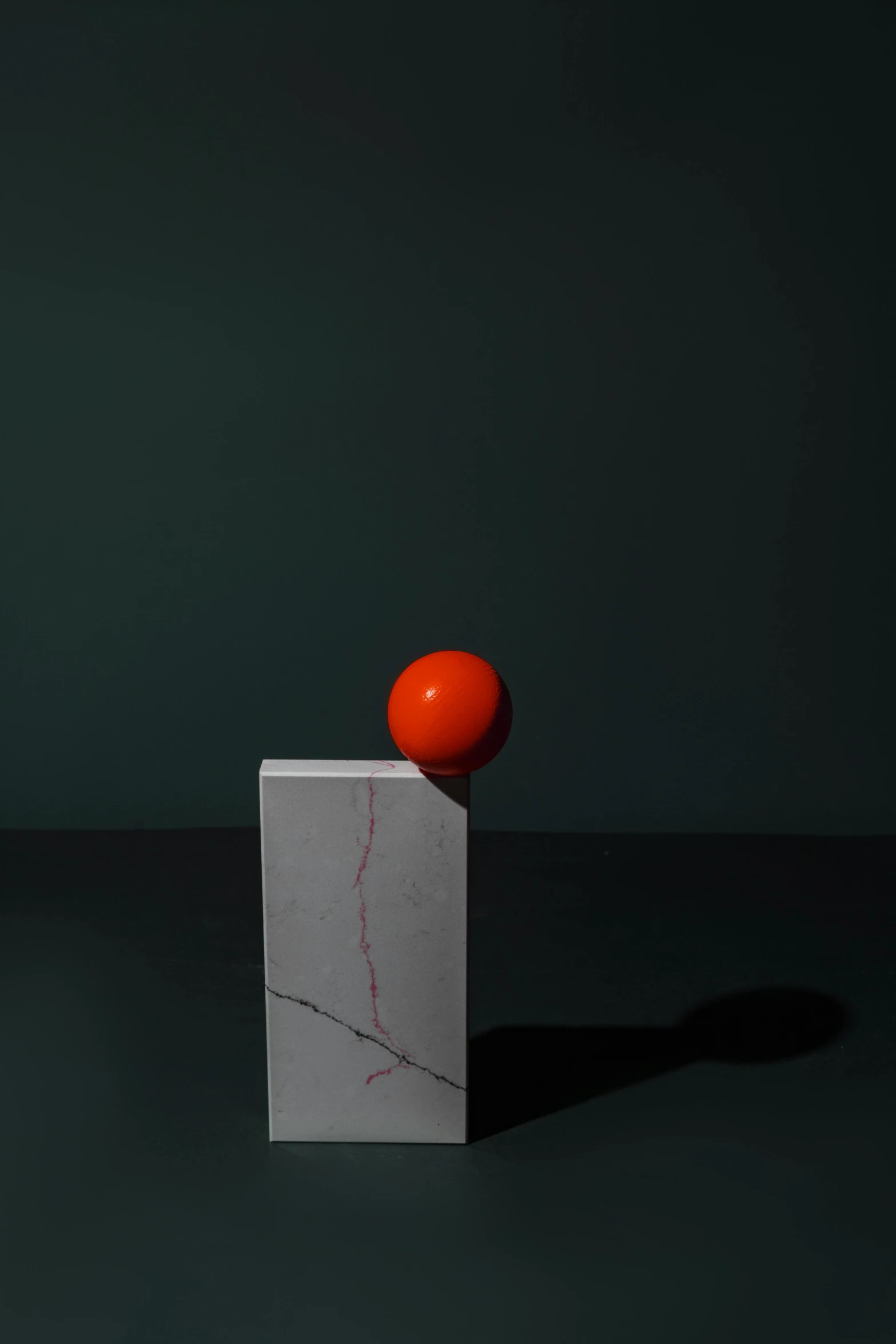 an orange sitting on top of a marble block, an abstract sculpture, inspired by Robert Mapplethorpe, red dot, ignant, color portrait, sense of movement