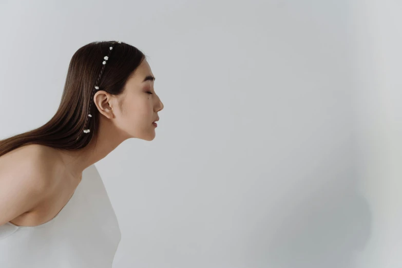 a woman with long hair wearing a white dress, inspired by Dai Xi, trending on pexels, lateral view, pearls, japanese collection product, white space
