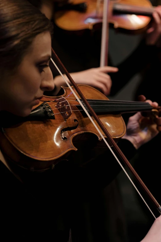 a close up of a person playing a violin, standing on top of a violin