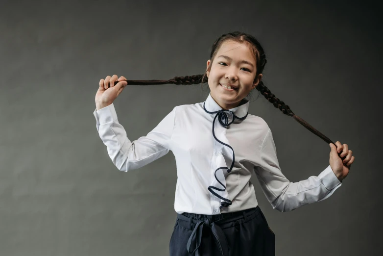 a little girl that is holding some kind of stick, inspired by Kim Tschang Yeul, pexels contest winner, danube school, collared shirt, hair in a ponytail. shirt, teenage female schoolgirl, being delighted and cheerful