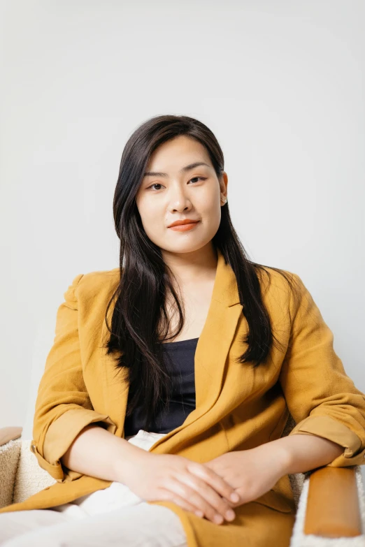 a woman sitting on a couch in a room, a portrait, by helen huang, wearing a blazer, on clear background, jinsung lim, engineer