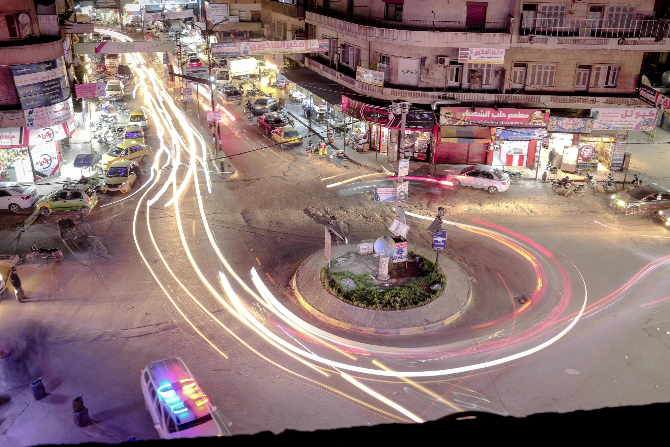 an aerial view of a busy city street at night, by Ahmed Yacoubi, spiraling, indore, talaat harb square cairo, screensaver